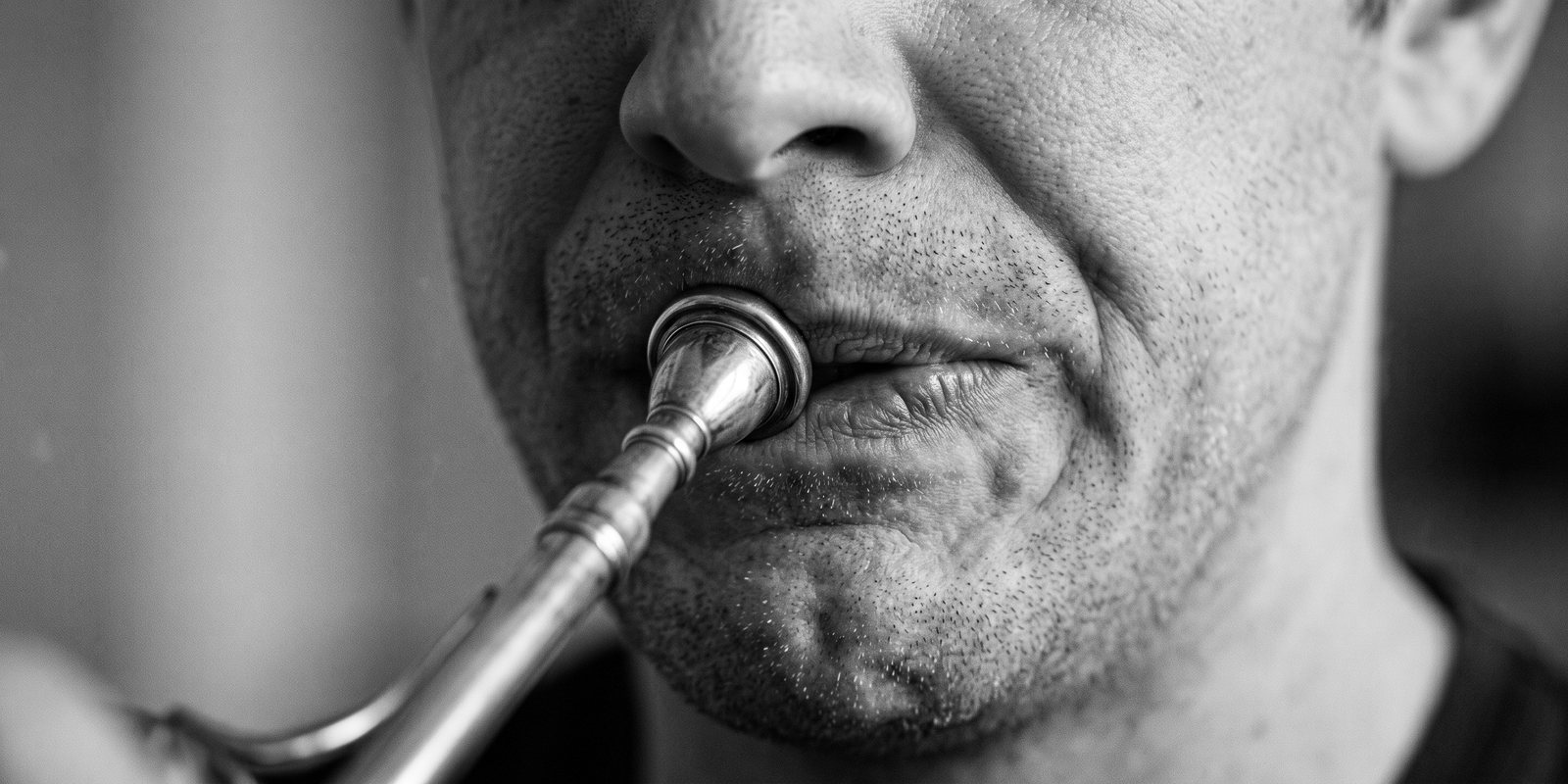 L’embouchure d’un corniste : les lèvres tirées d’un côté, le menton crispé.